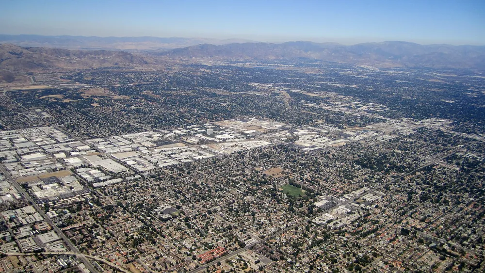 Aerial view over Northridge showing a dense grid of homes and tree-lined streets stretching toward the mountains of the San Fernando Valley