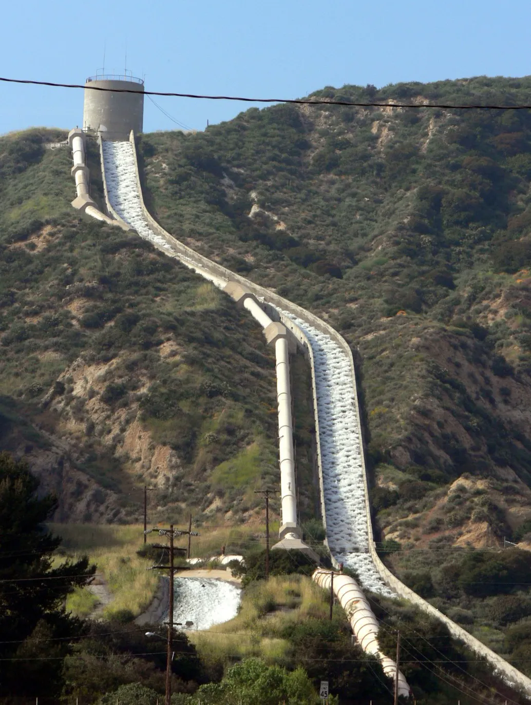 The Los Angeles Aqueduct Cascades spillway running down a brush-covered hillside in the Sylmar foothills