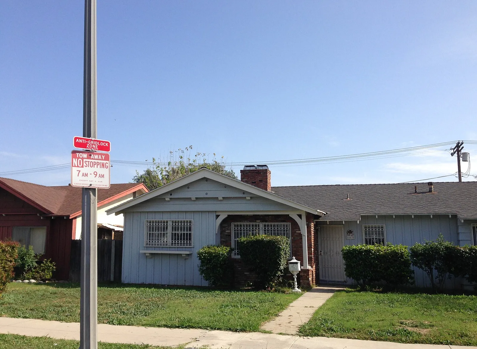 Single-story ranch-style homes with front lawns on a residential street in North Hills, Los Angeles