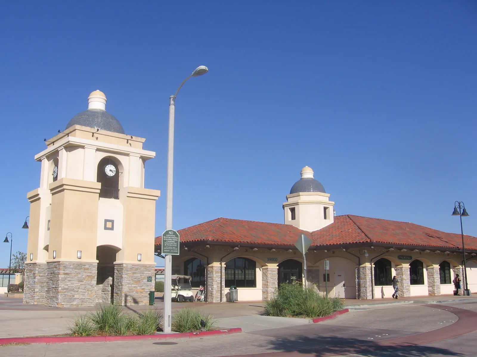 The Spanish-style clock-tower station building at the Palmdale Transportation Center under a clear blue sky