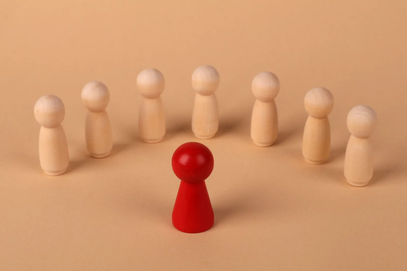 Red game piece standing out from a group of wooden pieces