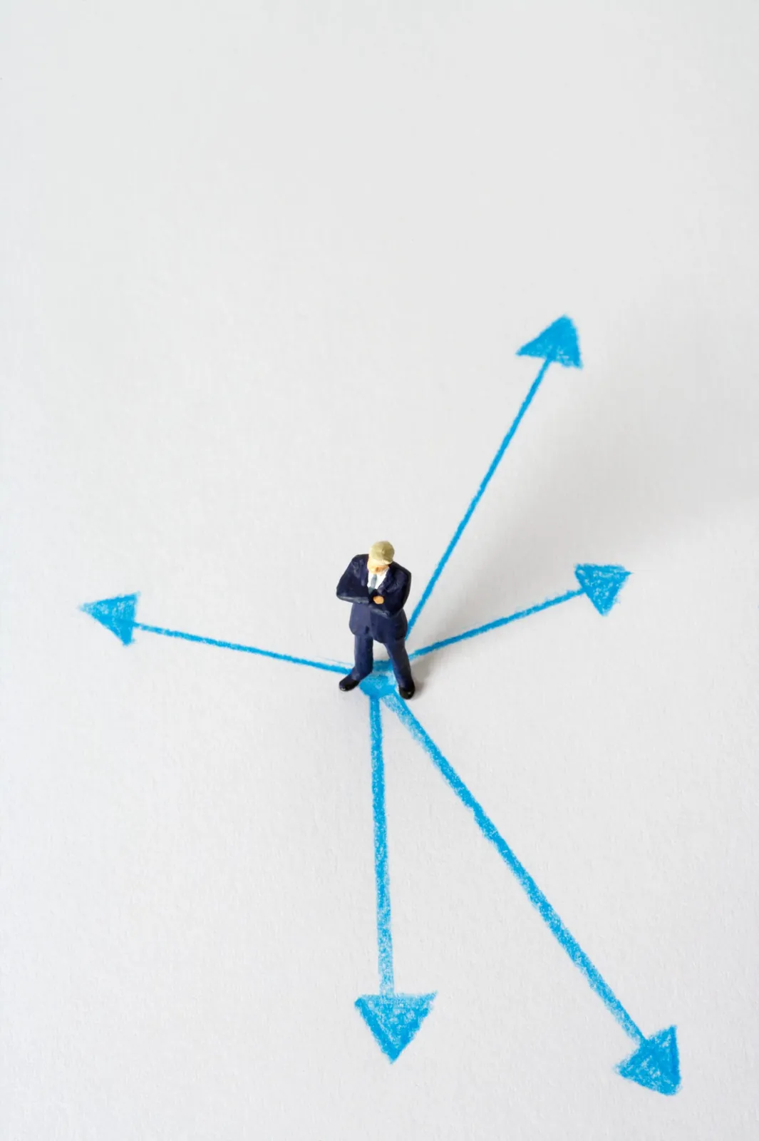 Miniature figure at the center of arrows pointing in many directions