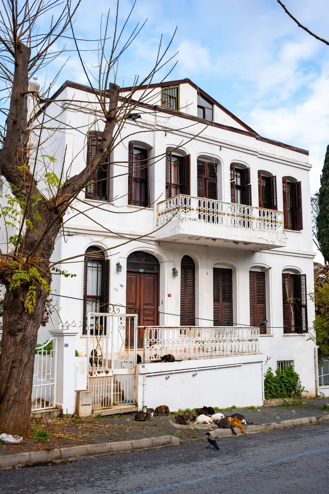 White two-story house with arched windows and a balcony