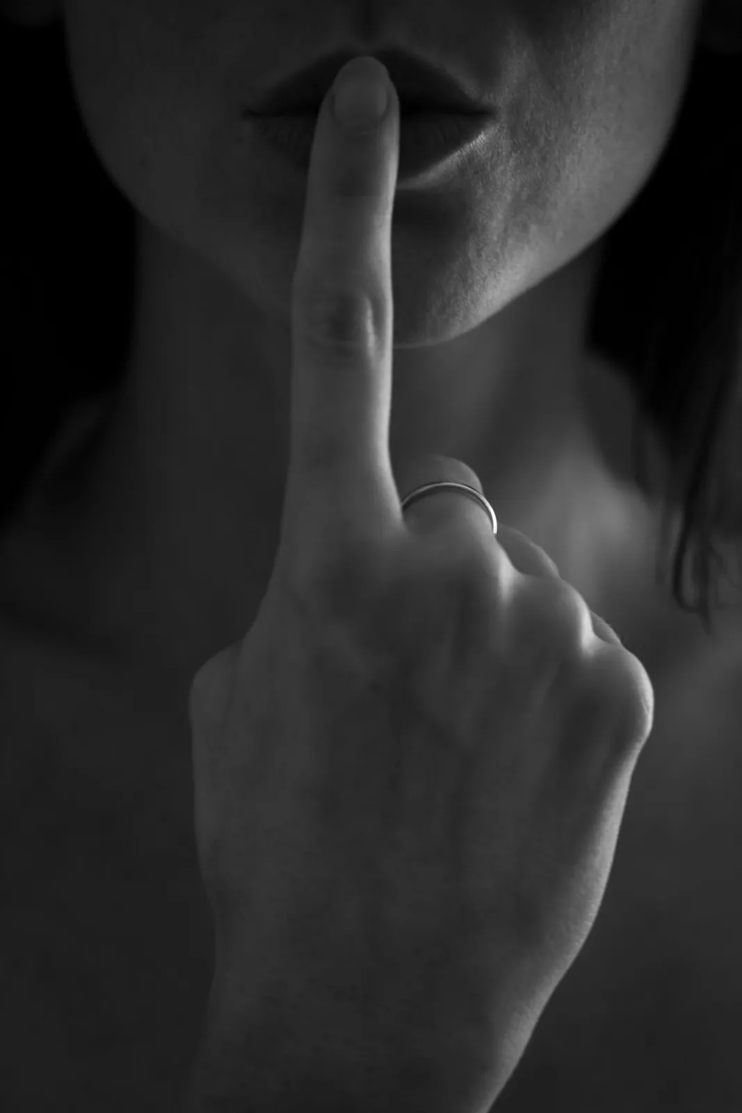 Person holding a finger to their lips in a 'quiet' gesture