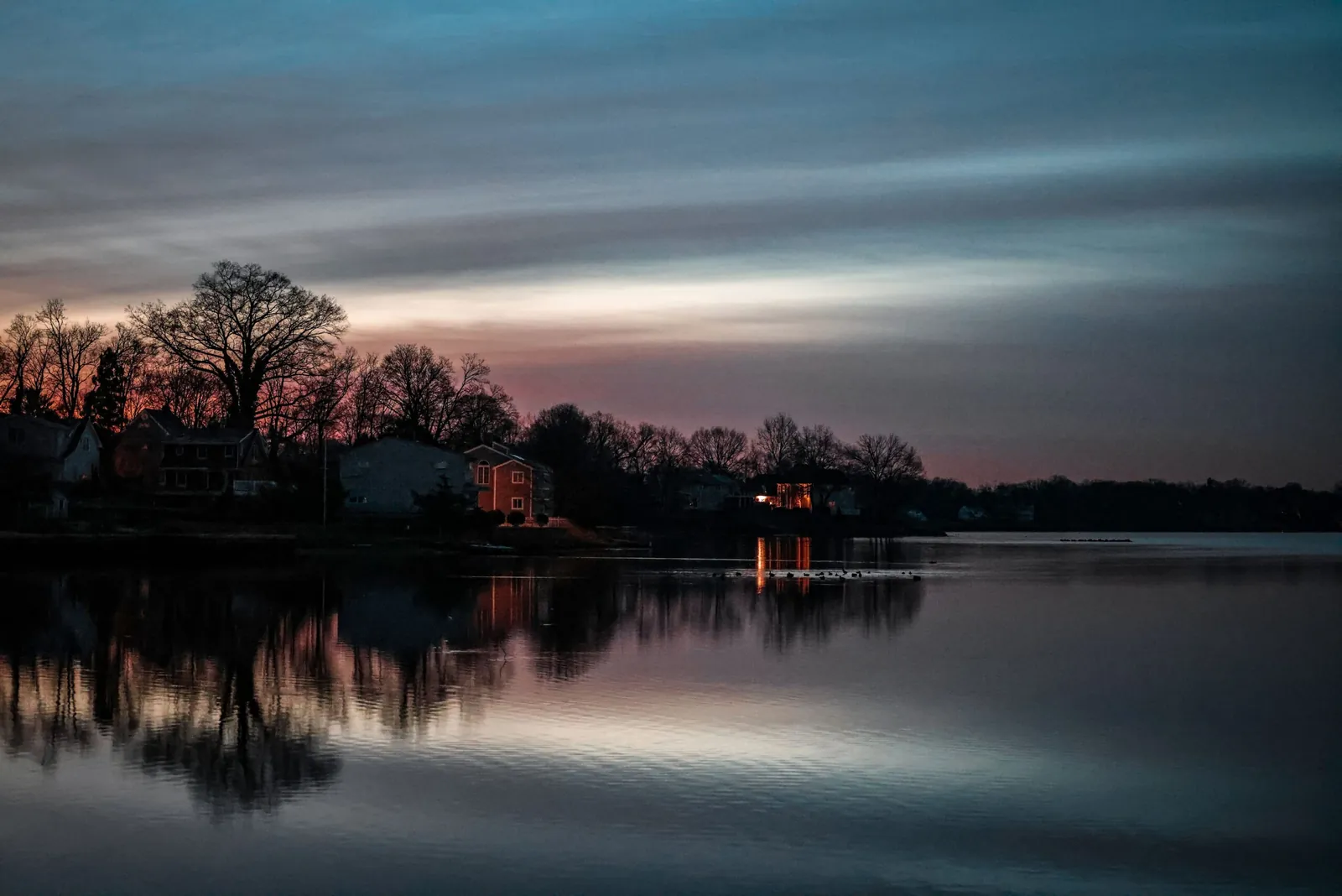 Lake at dusk with trees reflected in still water