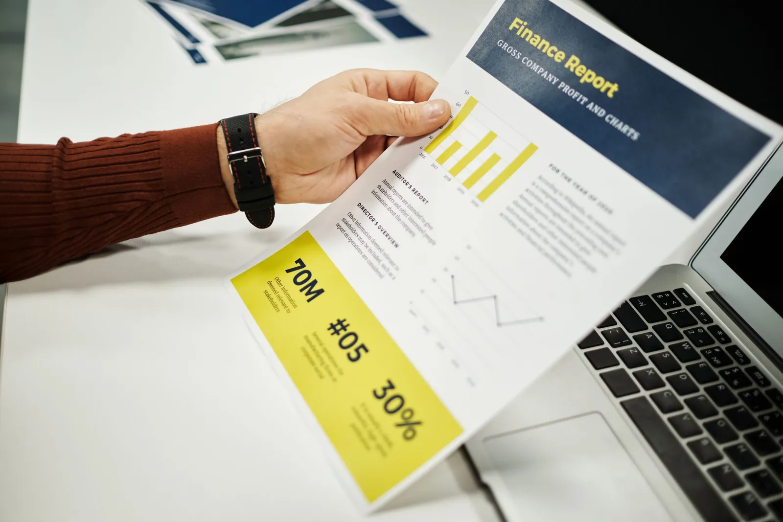 Person holding a printed financial report with charts