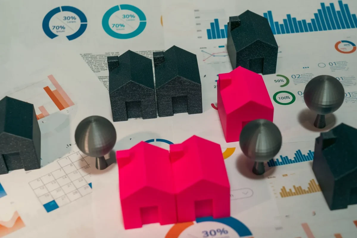 Small model houses and push pins on printed charts
