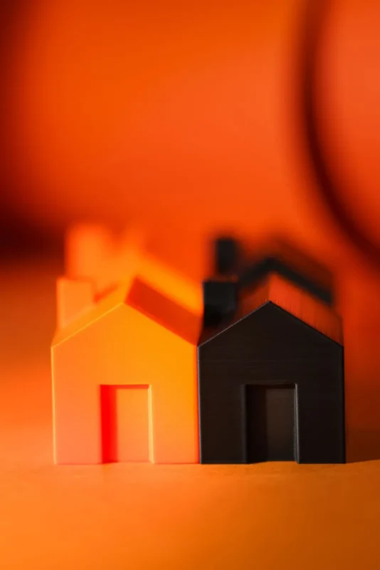 Two small model houses lit in orange light
