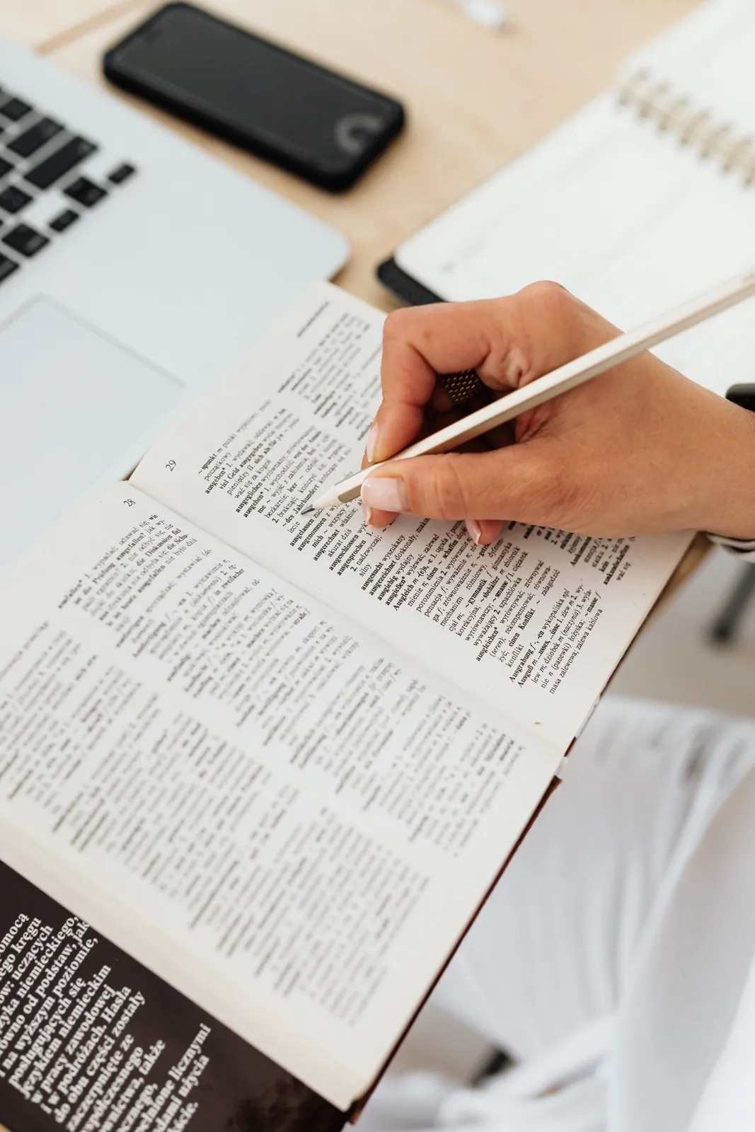 Person underlining text in a thick printed document