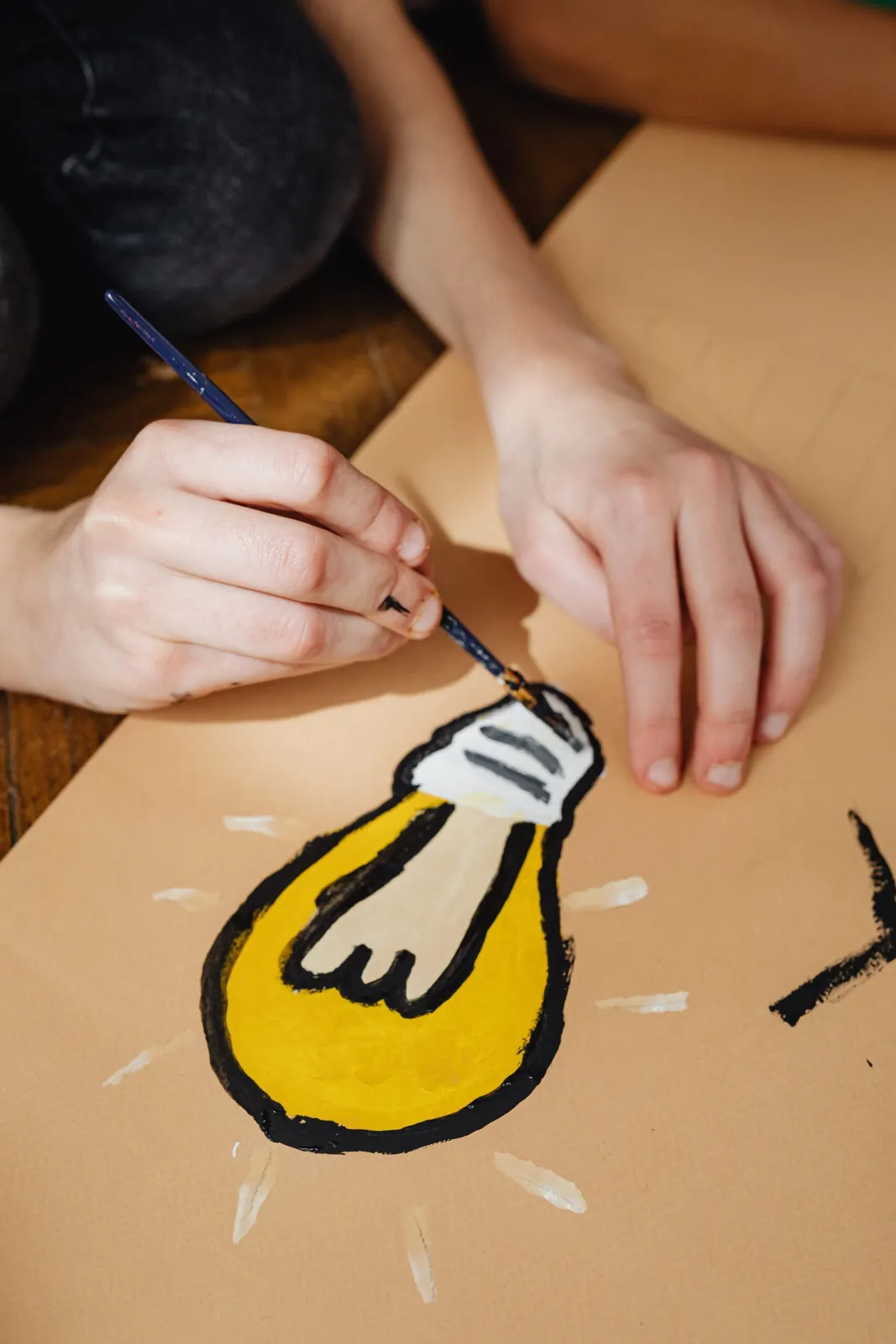 Hands drawing a light bulb idea on paper