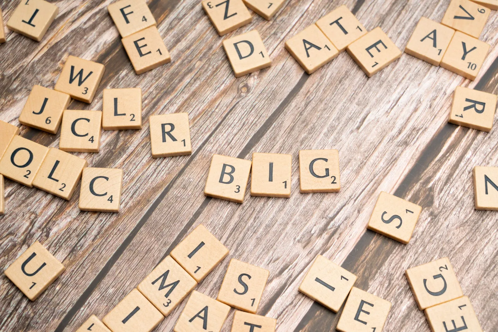Scattered letter tiles on a wooden table