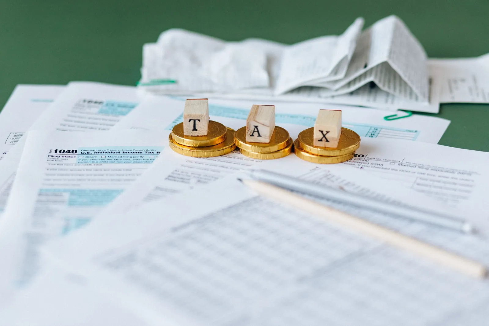 Tax forms with coins spelling 'TAX'