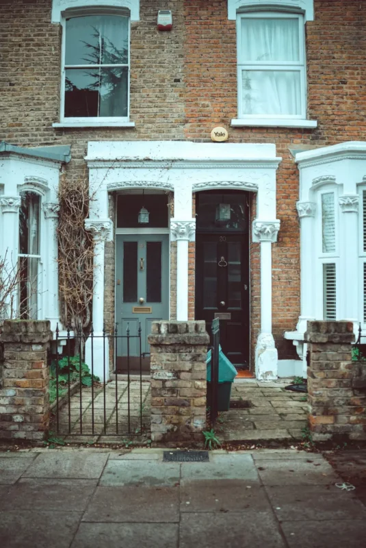 Brick row house with white-trimmed windows and a front gate