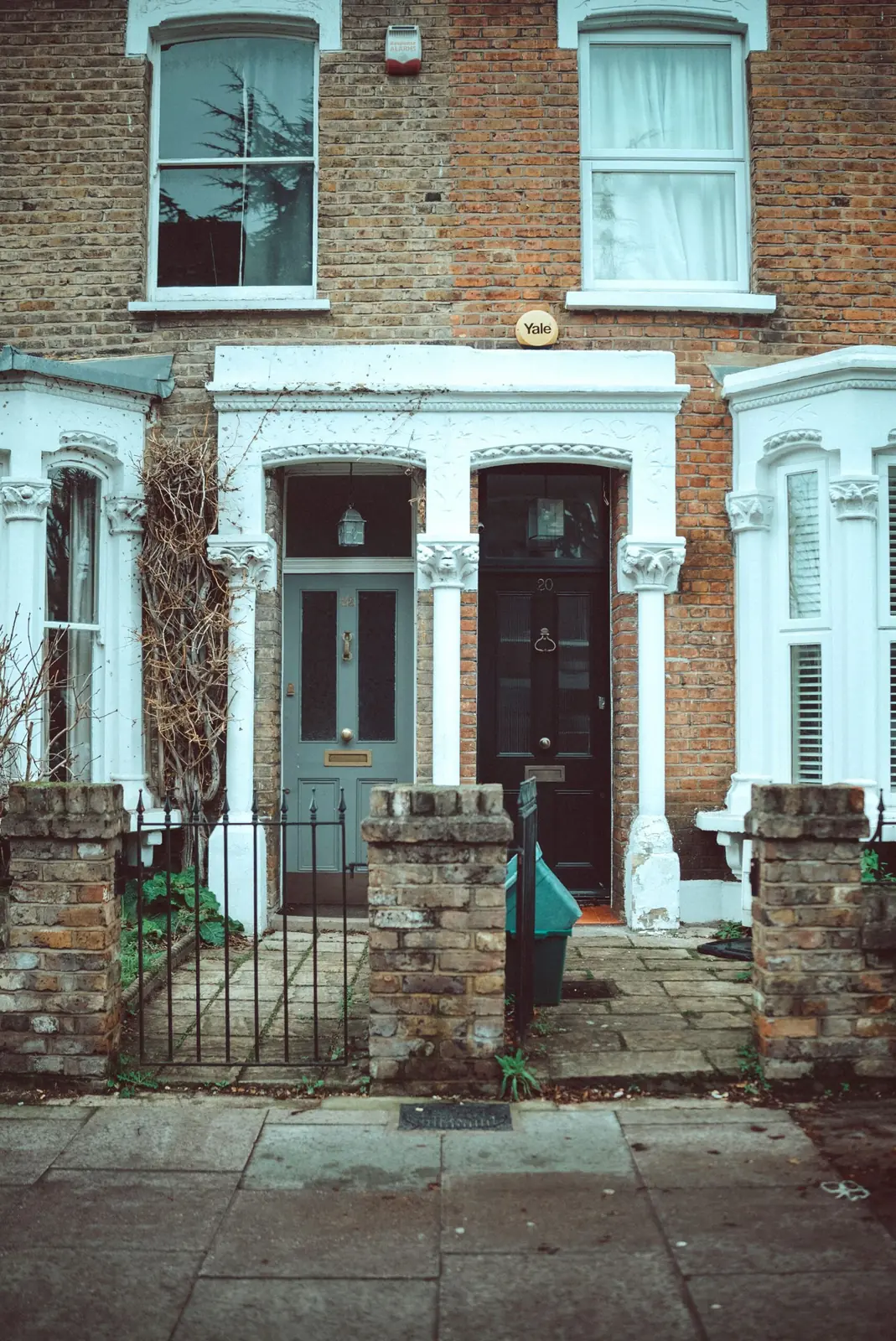Brick row house with white-trimmed windows and a front gate