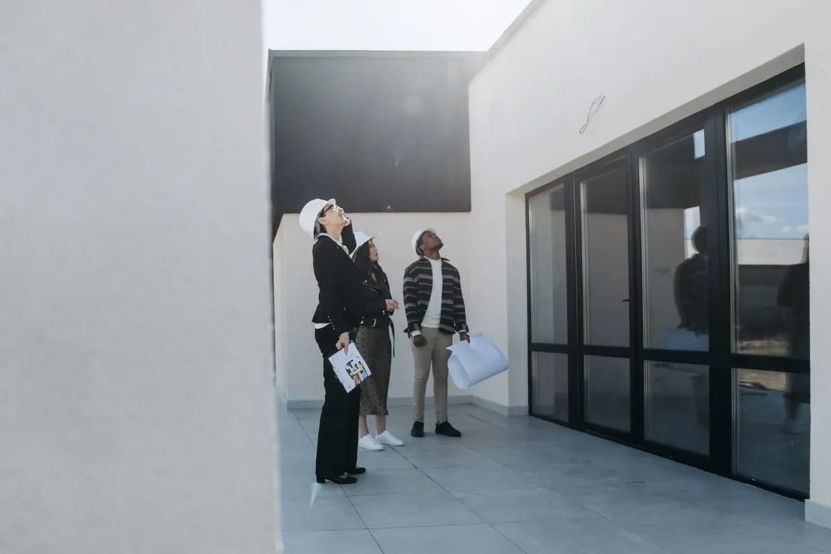 Agent showing two clients a modern empty home