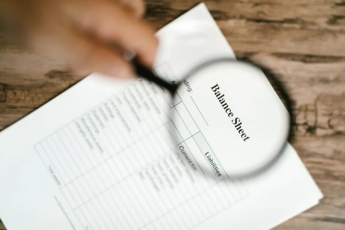 Magnifying glass over a balance sheet