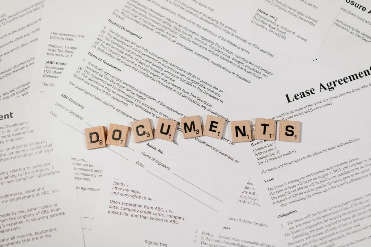 Letter tiles spelling Documents on printed lease agreement pages