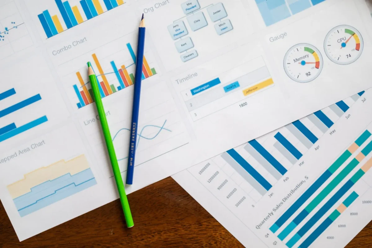 Printed charts and graphs with colored pencils on a desk