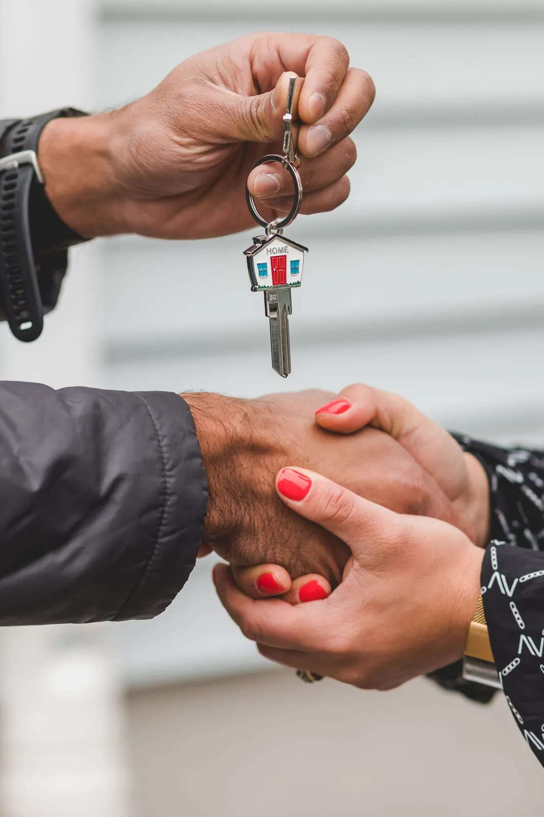 Agent handing house keys to a buyer during a handshake