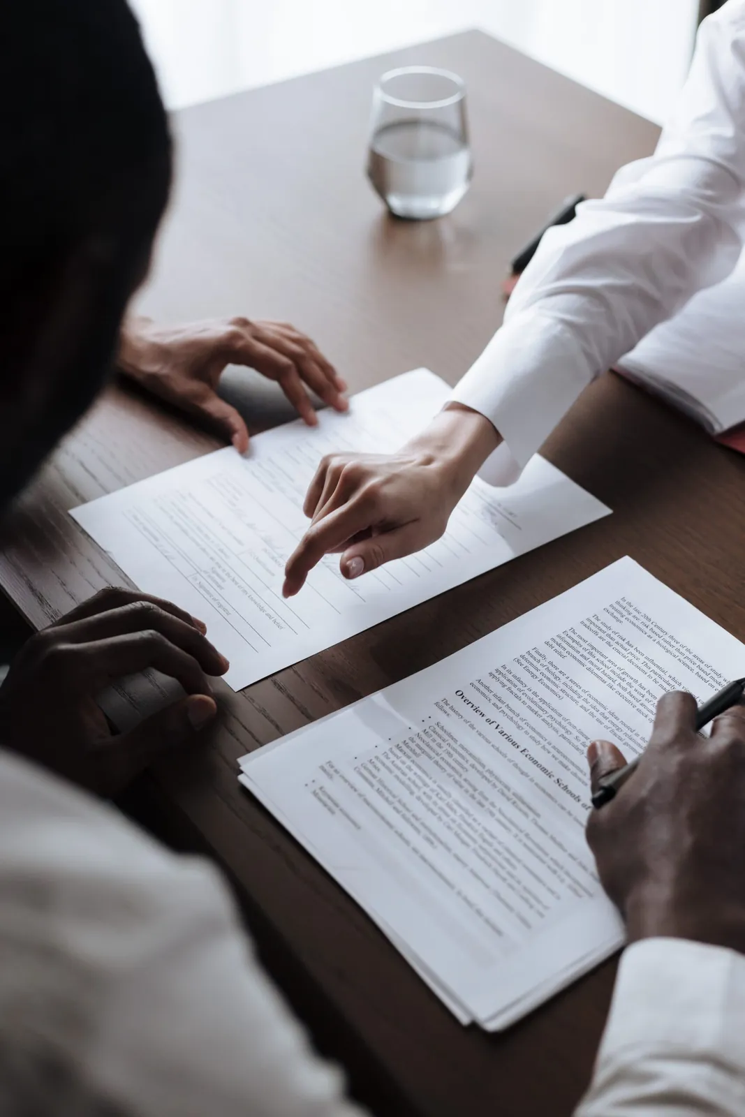Buyer and agent reviewing escrow paperwork at a table