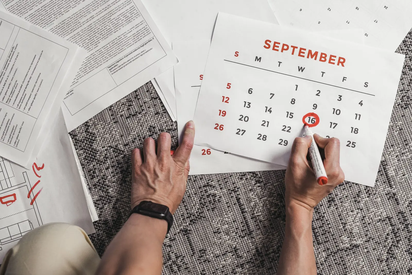 Hand marking a date on a September calendar