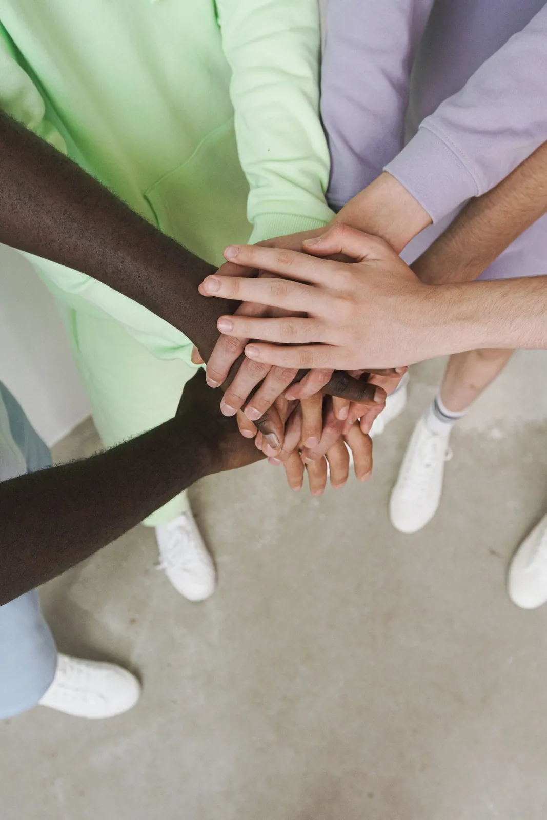 Group of people stacking hands in a team huddle