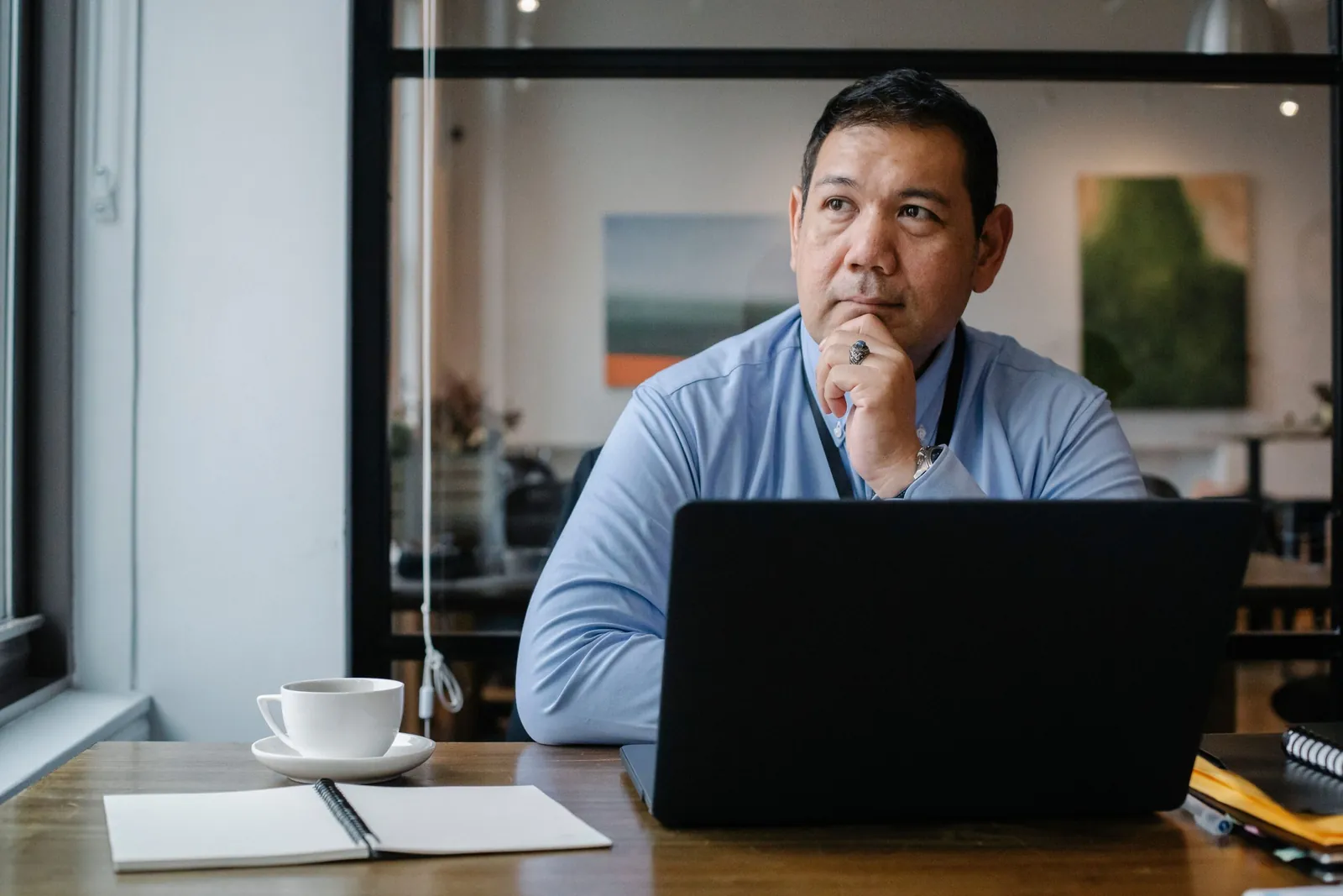 Man looking thoughtful at a laptop
