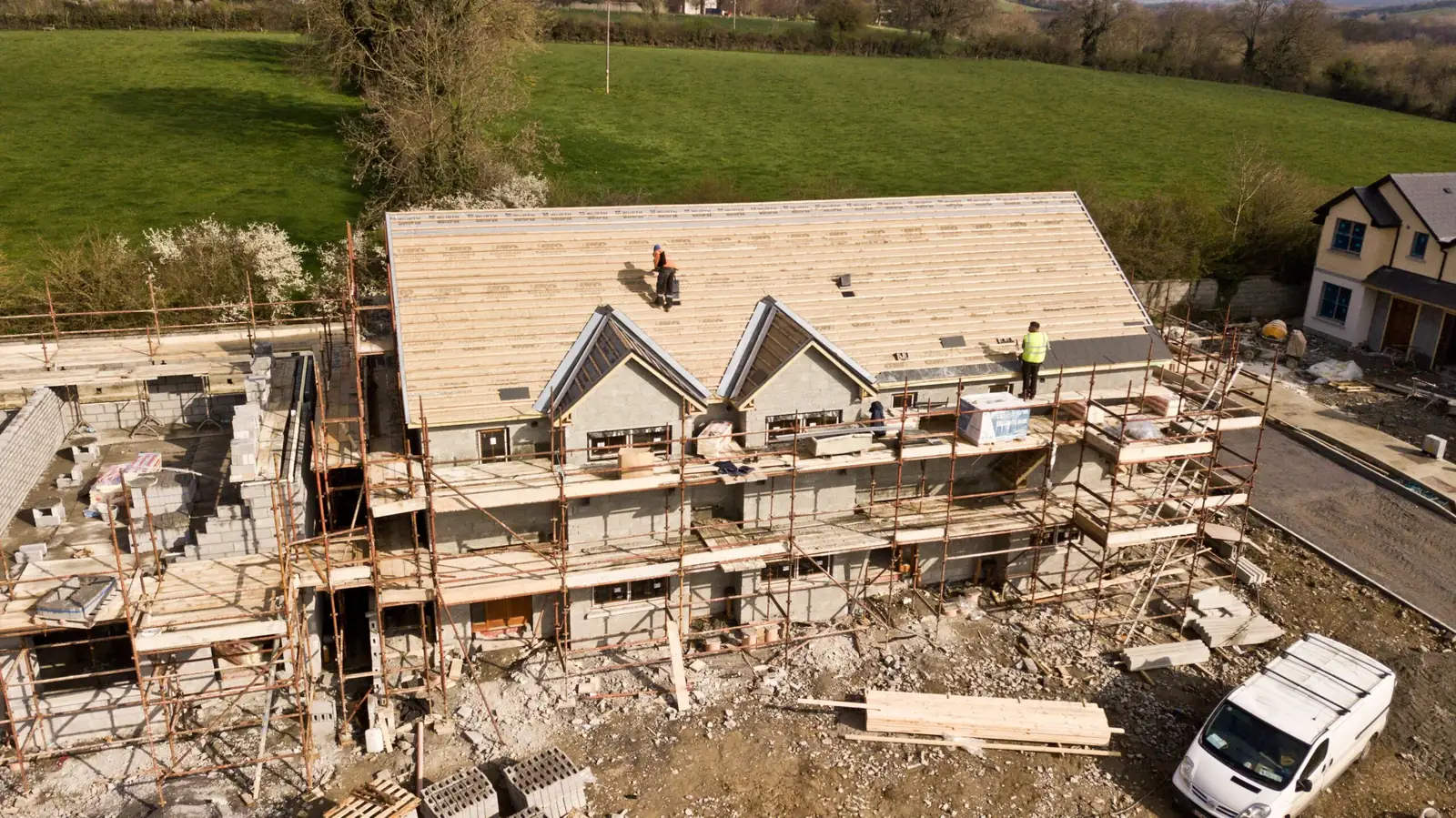 Aerial view of a house under construction with scaffolding