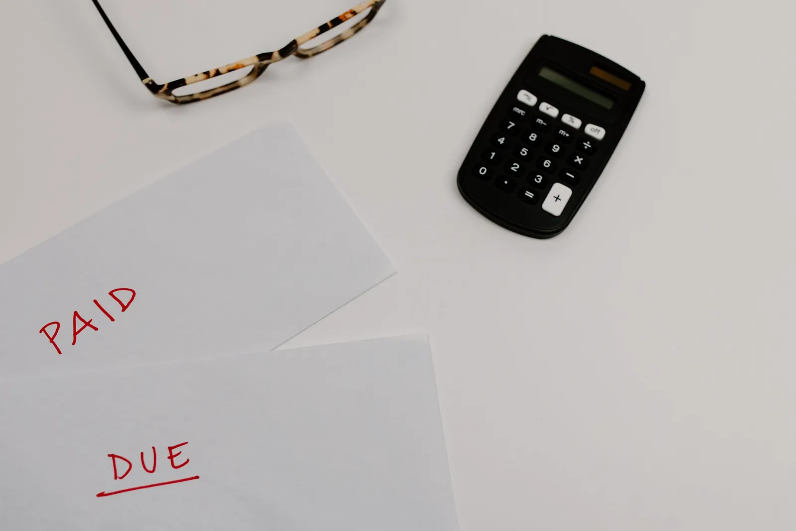 Envelopes marked 'Paid' and 'Due' with a calculator