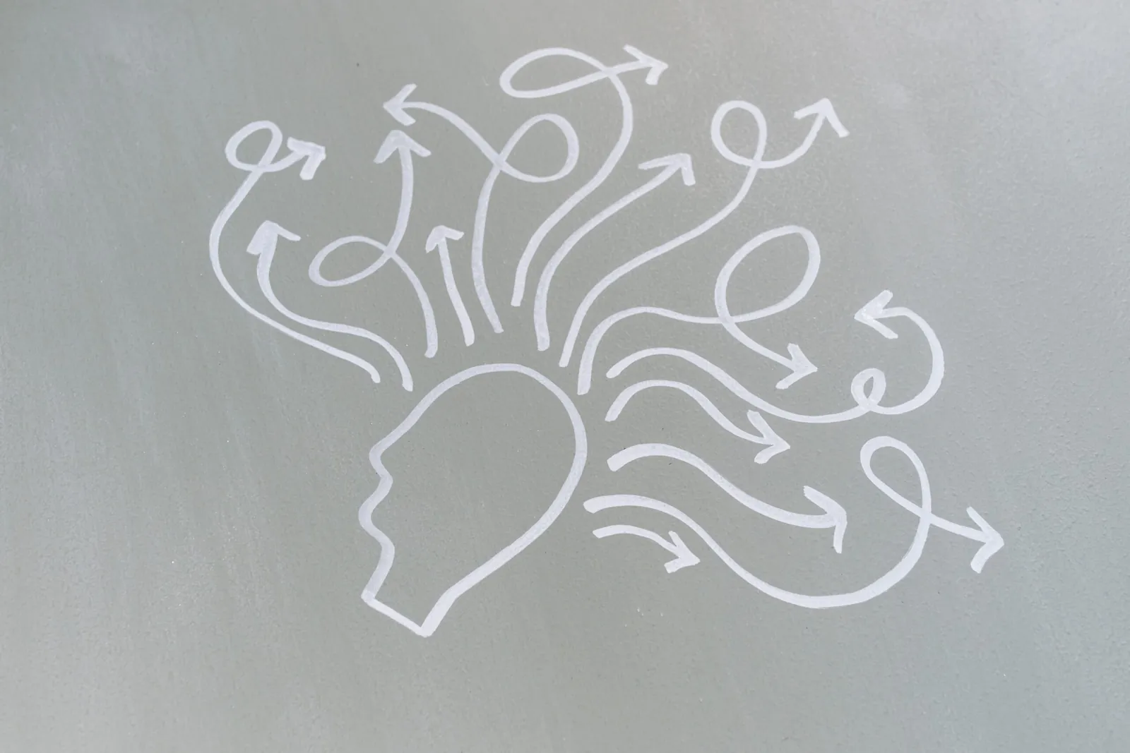 Chalk drawing of a head with arrows bursting outward