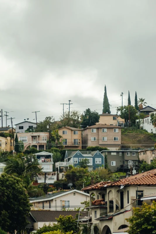 Hillside homes with red-tile roofs under a cloudy sky
