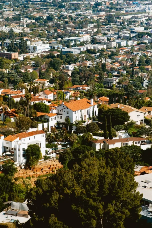 Hillside neighborhood of red-tile-roof homes among trees