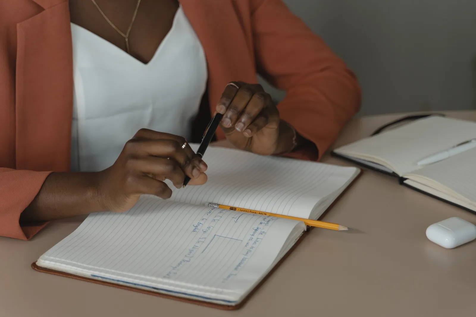 Person writing in a notebook at a desk